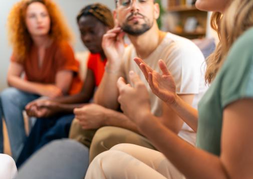 Petit groupe de personnes qui discutent assises en cercle.