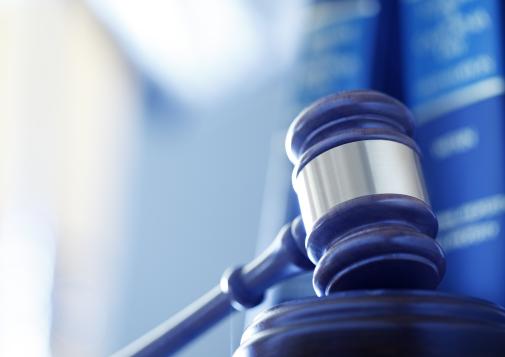 Close-up of a judge’s gavel with law books in the background.