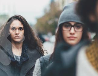 Three serious women walking outside. 