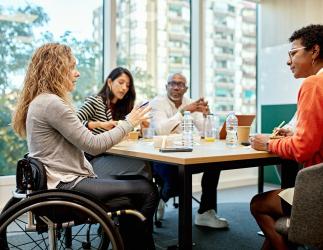 groupe de personnes assises autour d'une table discutant du travail.
