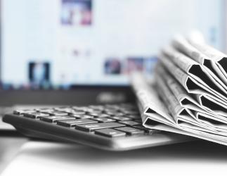 Pile of newspapers on a computer keyboard.