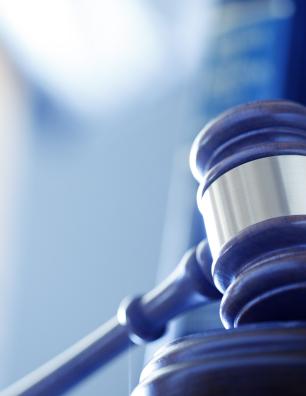 Close-up of a judge’s gavel with law books in the background.