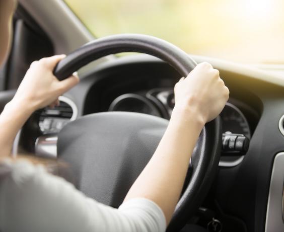 Two hands on a steering wheel. 