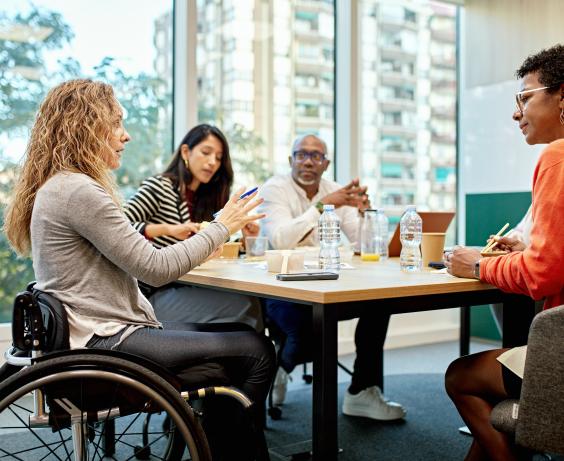 groupe de personnes assises autour d'une table discutant du travail.